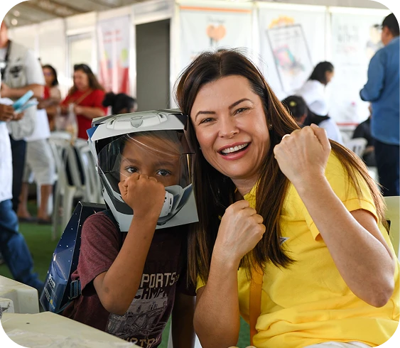 Marcela Passamani ao lado de uma criança em um evento comunitário