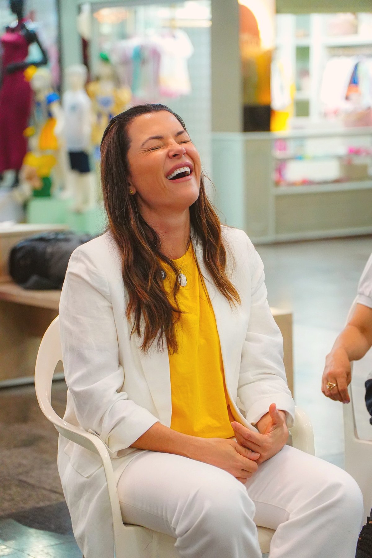 Marcela Passamani rindo durante uma conversa com moradoras